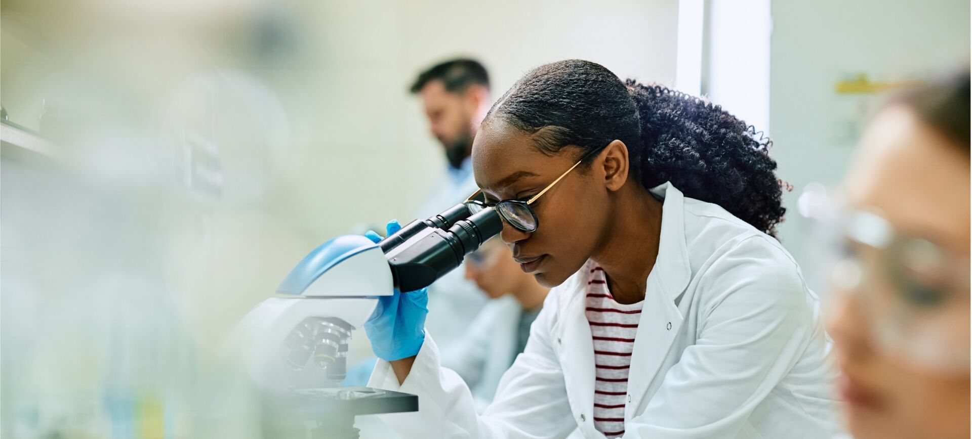 female scientist looking into a microscope