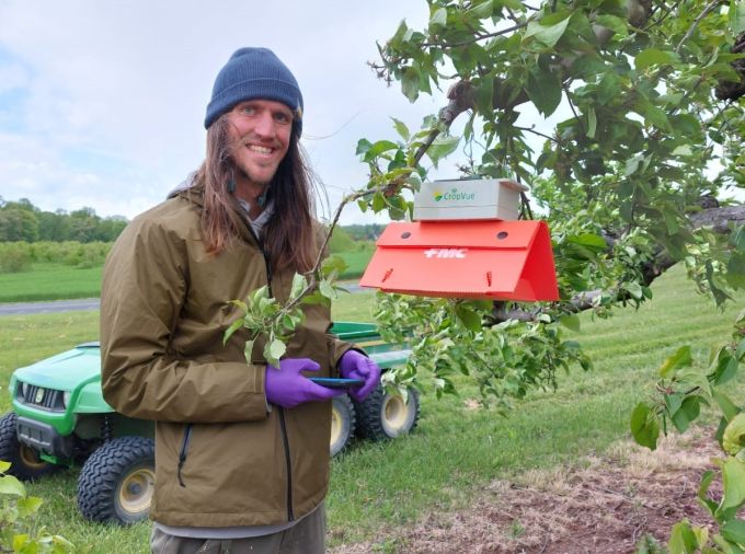 portrait of Tyler standing in an orchard