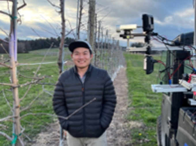 Pawikhum stands in an apple orchard