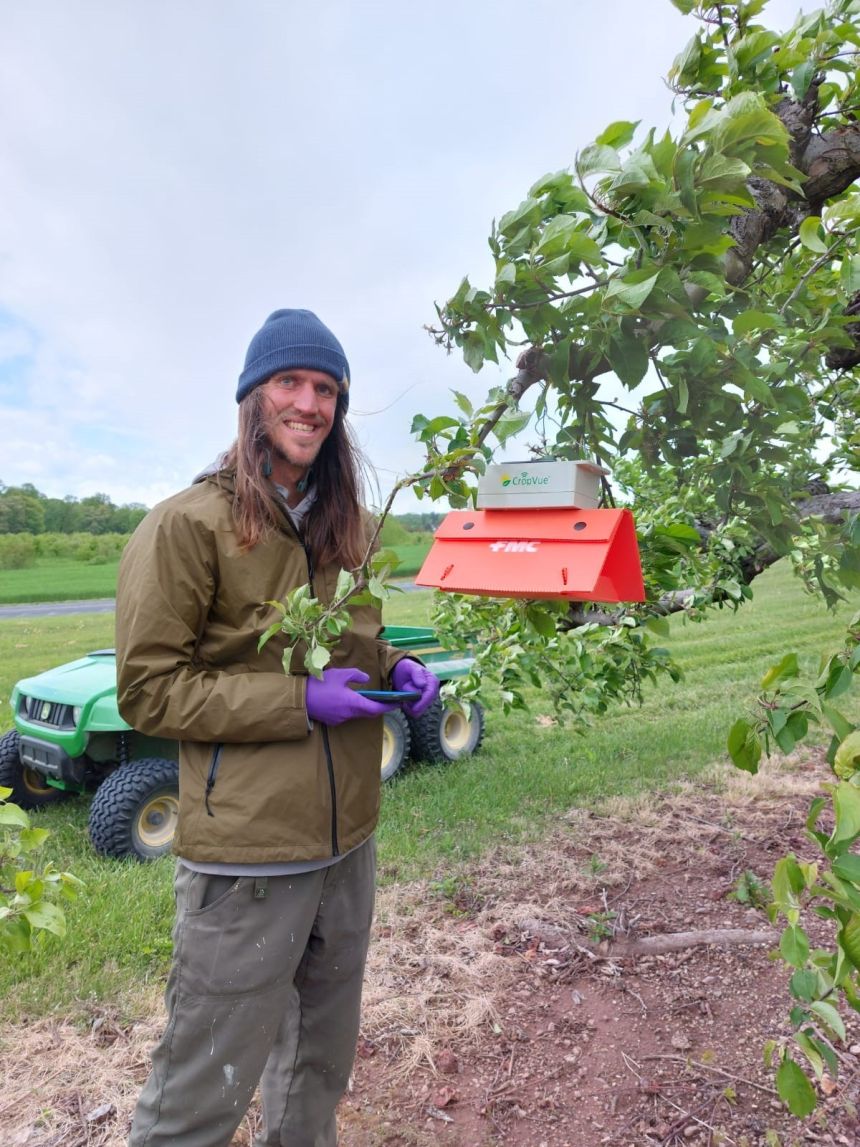 portrait of Tyler standing in an orchard