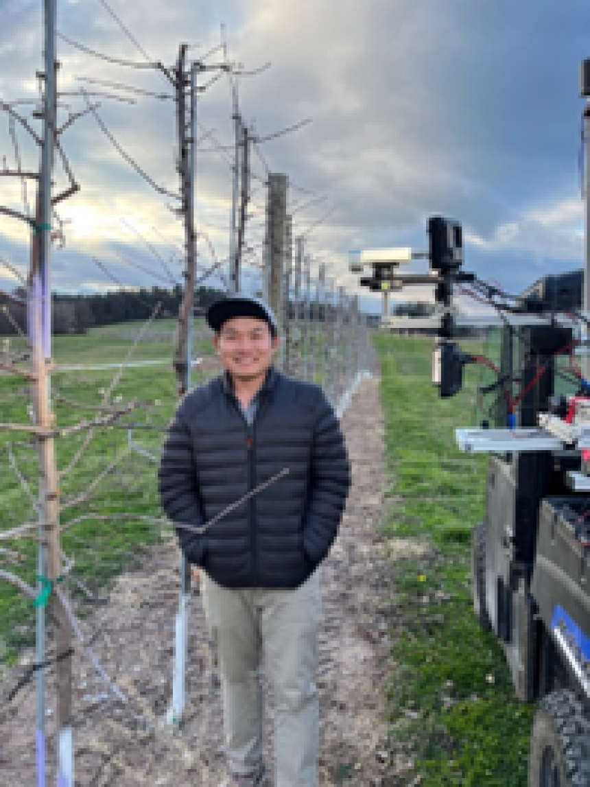 Pawikhum stands in an apple orchard